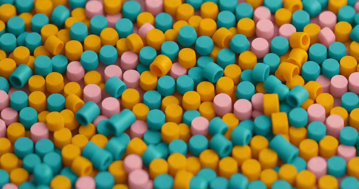 Close-up of ABS plastic pellets and molded parts